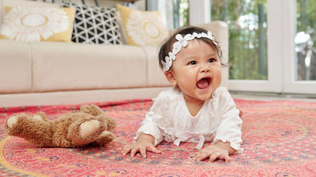 speech delay autism. developmental milestones image of a baby doing tummy time looking up smiling
