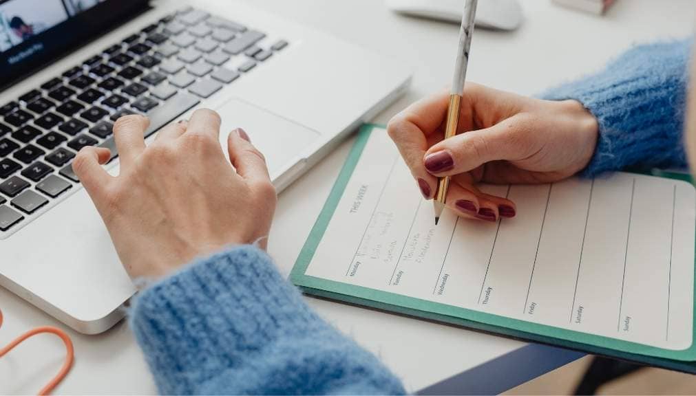 a homeschool mom sitting at a desk planning her homeschool week